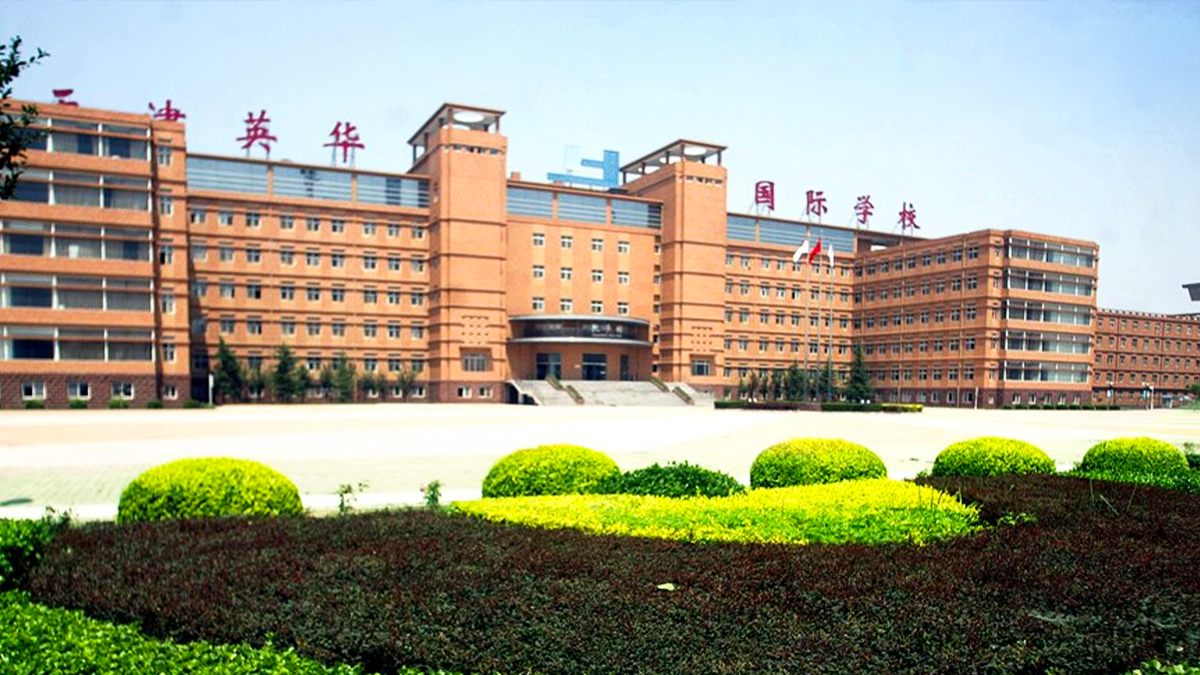 Tianjin Yinghua International School campus with orange buildings and manicured green landscaping displayed.