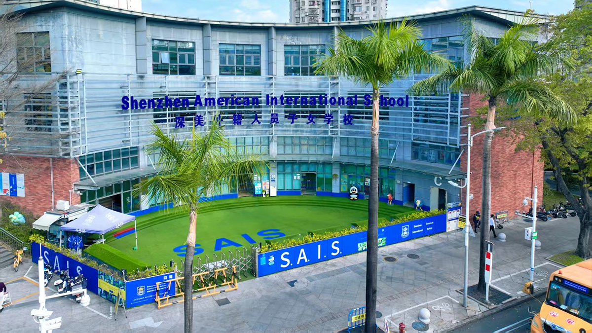 The Shenzhen American International School campus featuring modern glass architecture and tropical palm landscaping.
