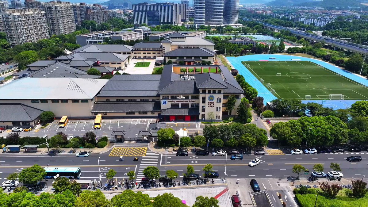 Aerial drone photography of Nanjing International School campus with sports facilities buildings.