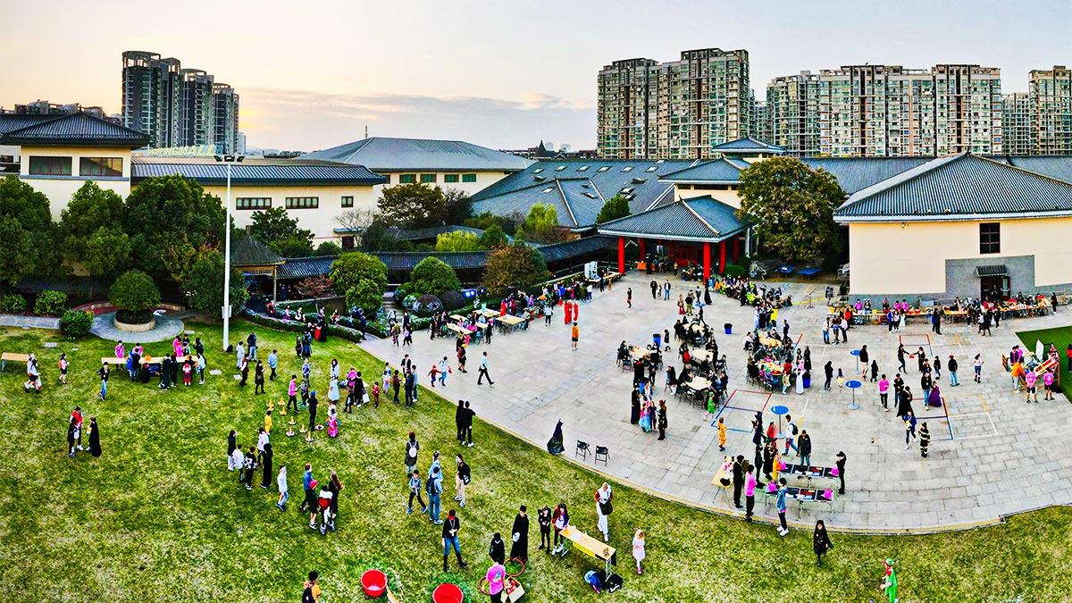 Aerial view of Nanjing International School campus with students gathered for outdoor event.