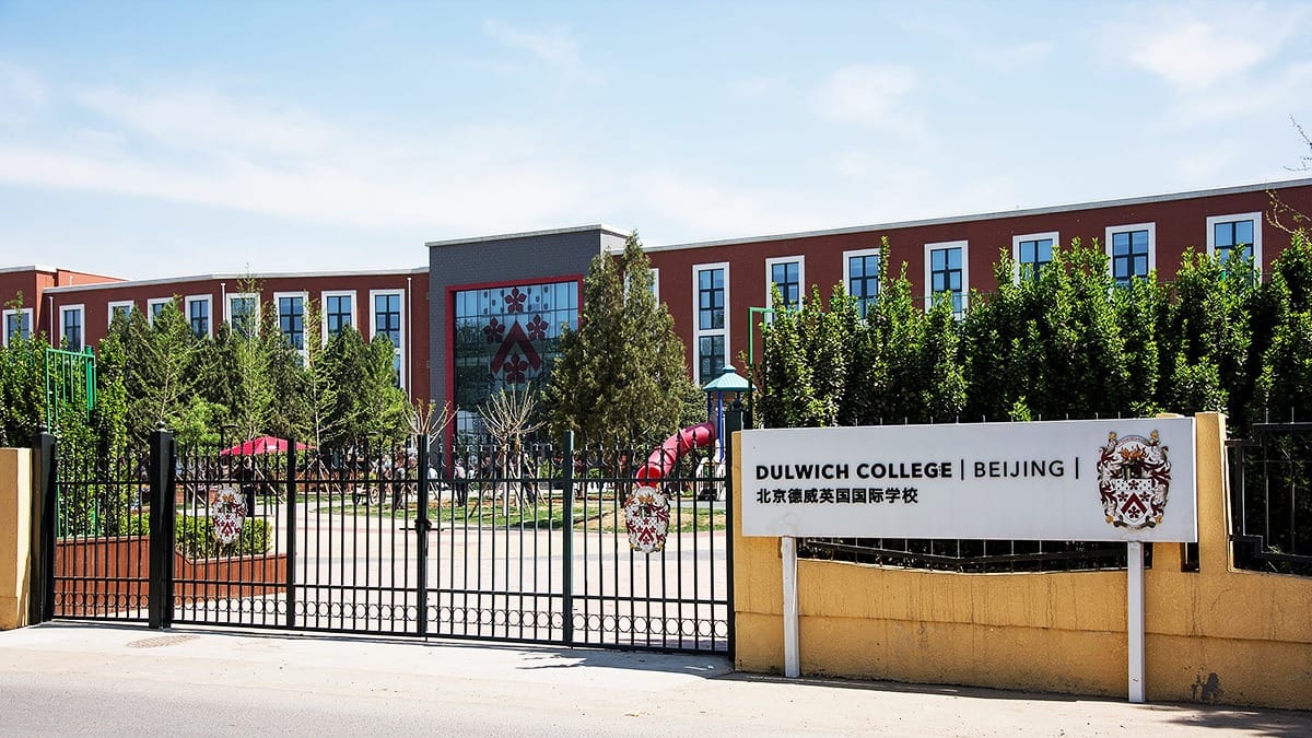 Dulwich College Beijing entrance gate with school sign and red brick campus building