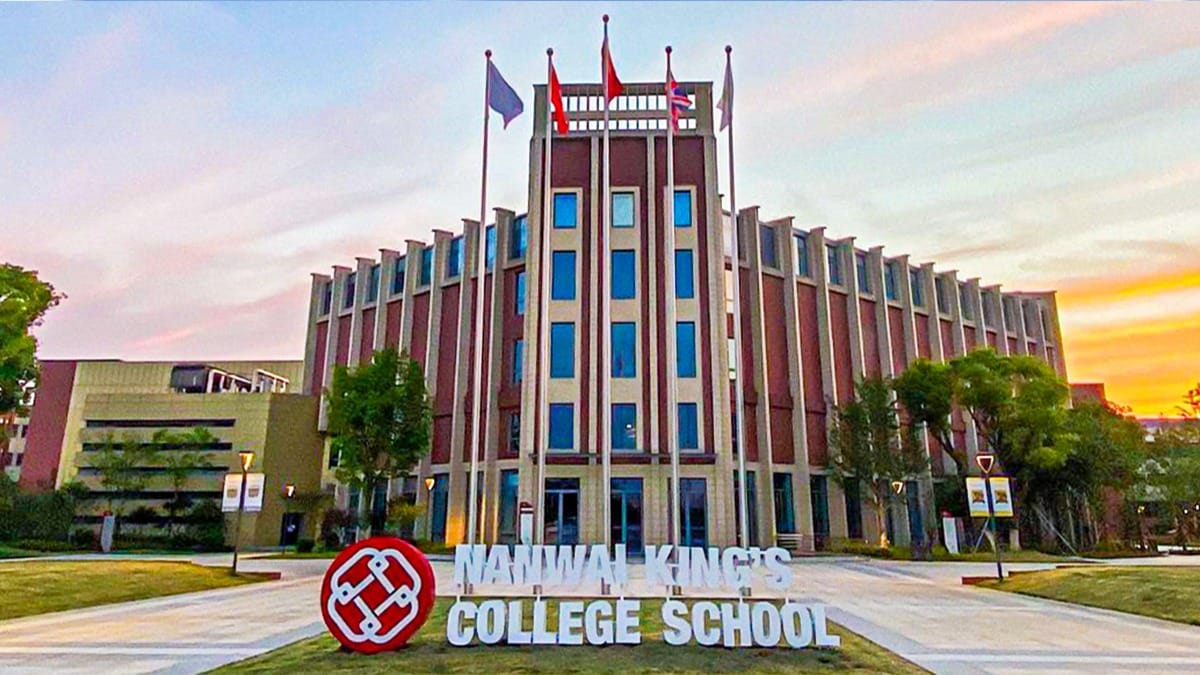 Wuxi Dipont School of Arts and Science main building with flags at sunset