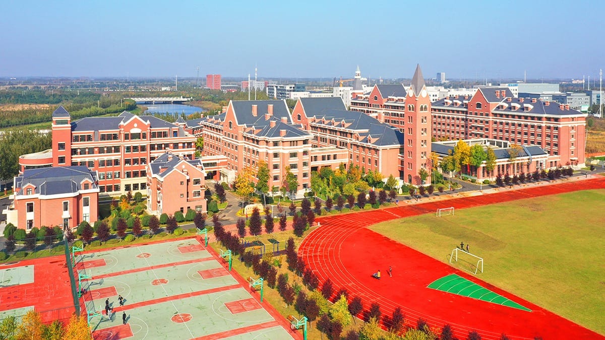 Harbin Meijia Foreign Language School campus aerial view with red track and sports facilities