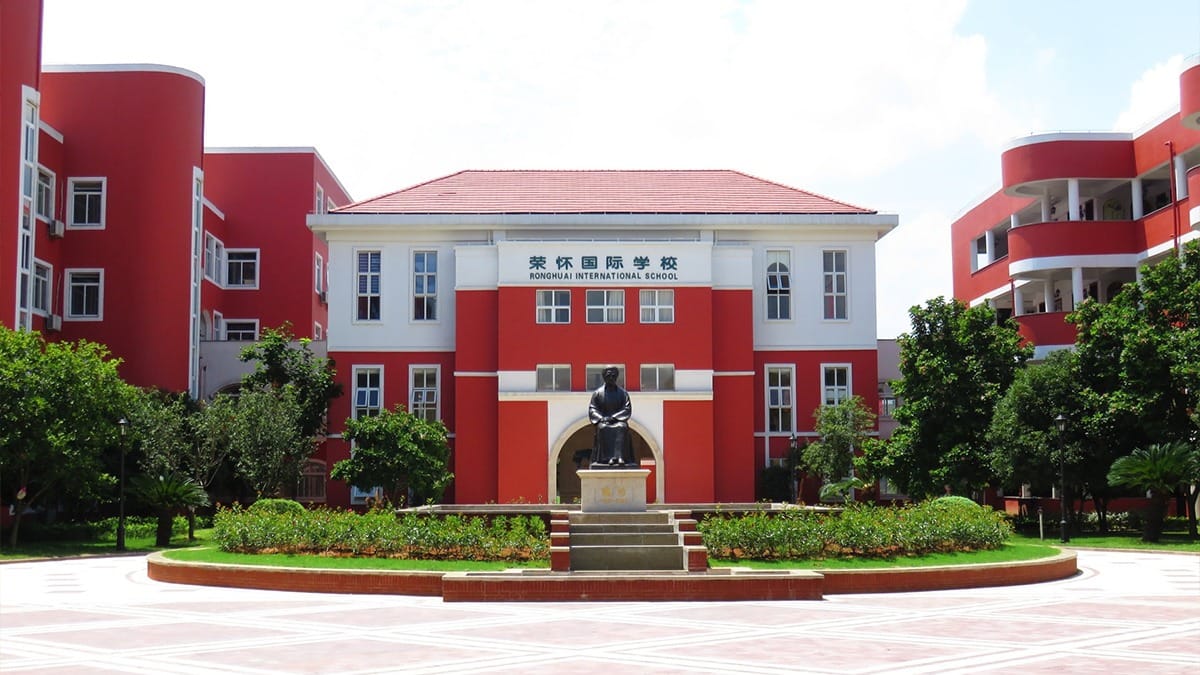 Ronghuai International School campus courtyard with red and white buildings and sculpture