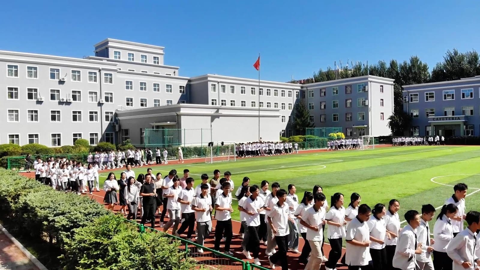 Harbin Wanbang School students gathered on sports field during outdoor assembly