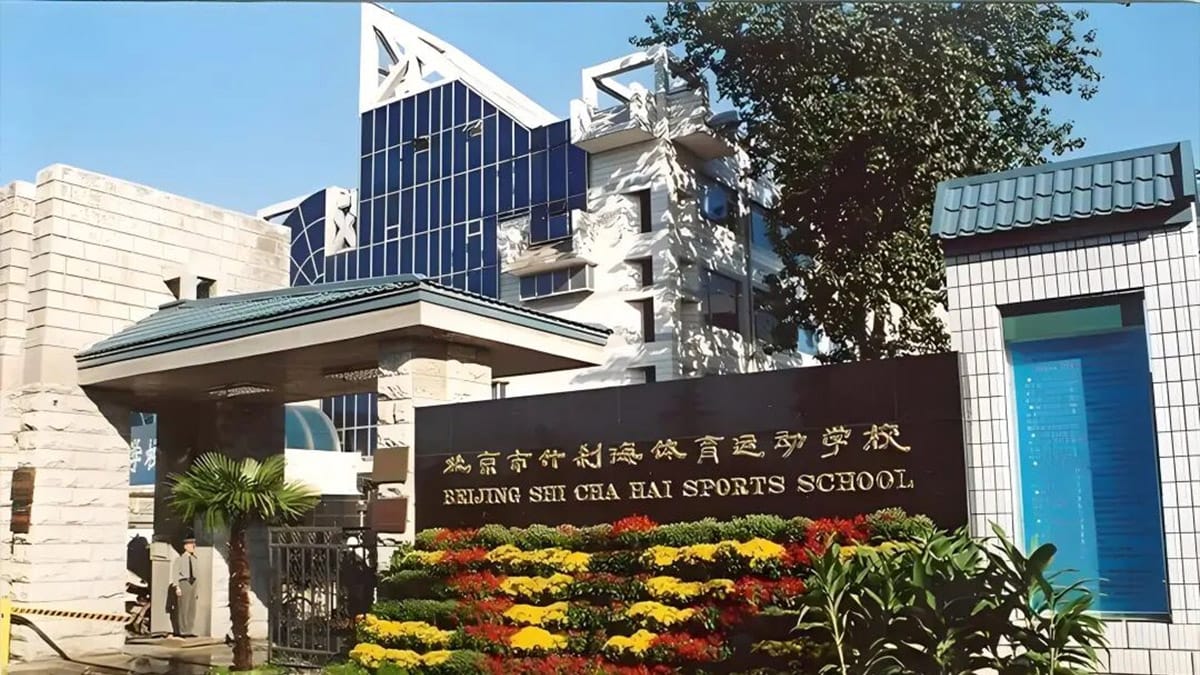 Beijing Shichahai Sports School entrance with bilingual signage and flower gardens