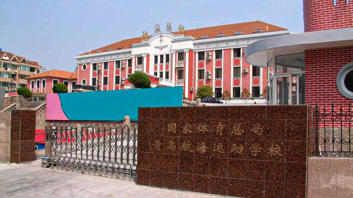 Qingdao Sports School entrance gate with distinctive red and white campus buildings