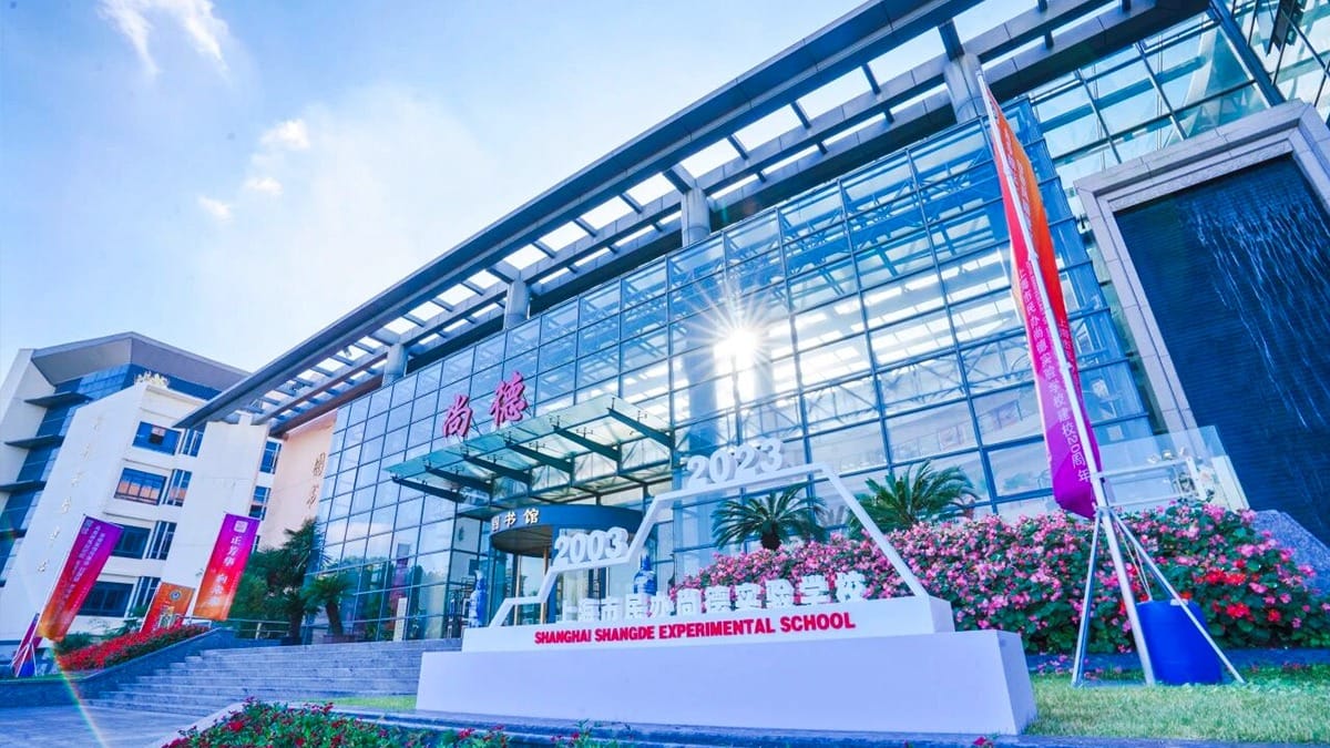 Shanghai Shangde Experimental School glass facade building with flower gardens