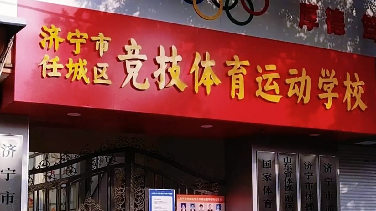 Jining Sports School red banner entrance with Olympic rings and gold Chinese lettering