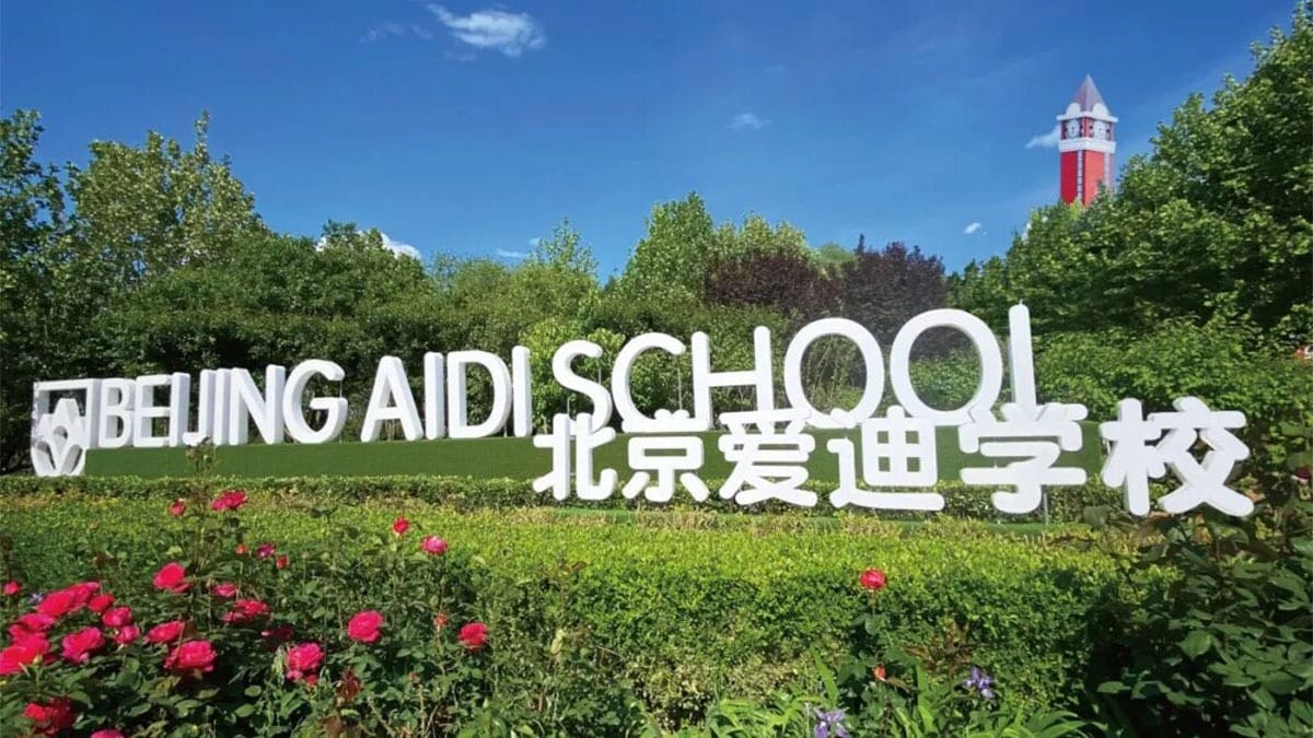 Beijing Aidi School campus entrance with clock tower and landscaped gardens